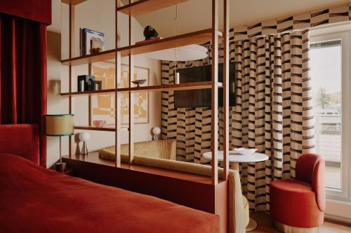 - une chambre avec un lit rouge et une table dans l'établissement Locke am Platz Zurich, à Zurich
