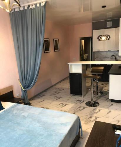 Zimmer mit einem Bett, einem Schreibtisch und einem Vorhang in der Unterkunft VIP apart 525 in Tbilisi City