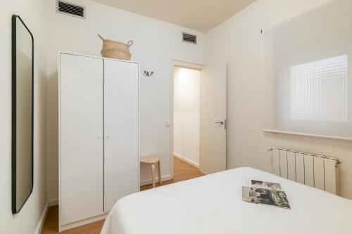 1 dormitorio con cama blanca y espejo en Rafael Apartment by Olala Homes en Hospitalet de Llobregat