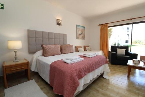 een slaapkamer met een groot bed en een rode deken bij Camélia 89 São Rafael - Albufeira, Algarve in Albufeira