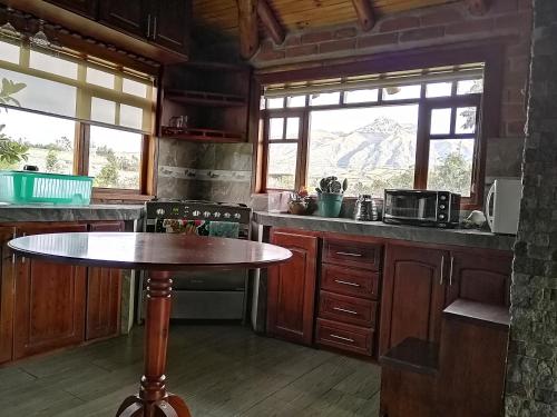 a kitchen with a table in the middle of it at Cabaña Puñushiki kalera Lodge 