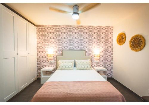 um quarto com uma cama e duas luzes na parede em Flores de Cordoba Azahar 1 em Córdoba