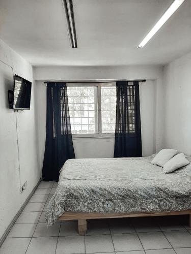 1 dormitorio con cama y ventana en Complejo Turístico Quinto Elemento 2 en San Rafael