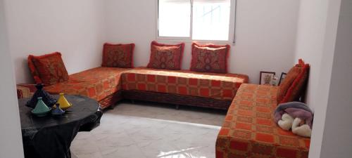 uma sala de estar com um sofá e uma mesa em Qamar's guests 4 em Al Hoceïma