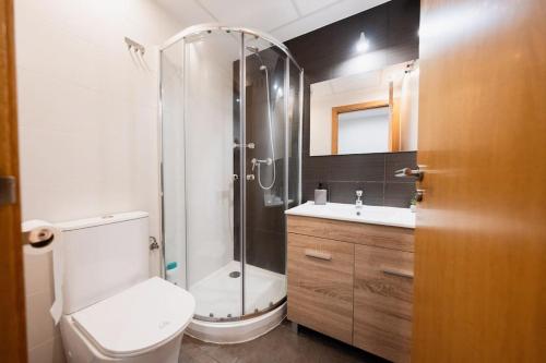 a bathroom with a shower and a toilet and a sink at Chic City Haven: Modern Apartment in Castellón in Castellón de la Plana