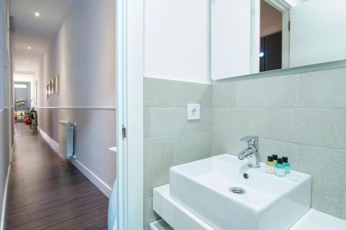 ein Bad mit einem Waschbecken und einem Spiegel sowie einem Flur in der Unterkunft APARTAMENTO EN SANTA ANA - SOL (2H + 2B) in Madrid