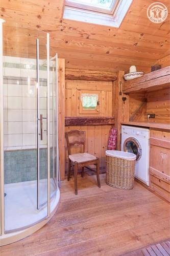 une salle de bain avec douche et machine à laver dans l'établissement Chalet de Marie proche des Saisies, à Queige