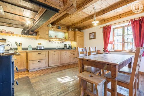 a large kitchen with a wooden table and chairs at Chalet de Marie proche des Saisies in Queige