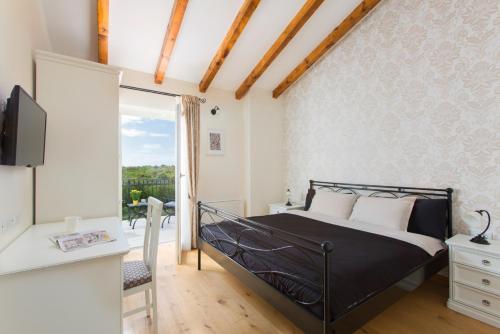 a bedroom with a black bed and a balcony at Villa Aurora near Rovinj for 8 persons with sea view & whirlpool in Bale