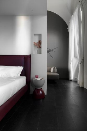 a bedroom with a bed and a toilet in it at Palazzo Giusti Suites and Spa in Urbino