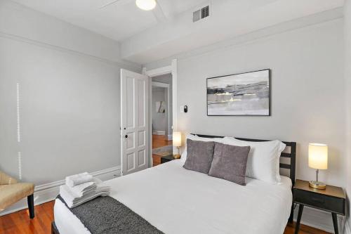 biała sypialnia z łóżkiem i krzesłem w obiekcie 2BR Bright and Lovely Apt - Leland 3 w Chicago