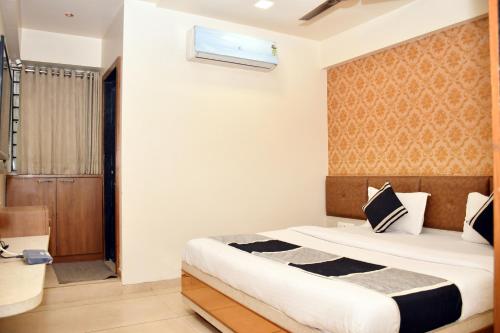 a bedroom with a bed and a window at Hotel Bharosa inn Naroda in Ahmedabad