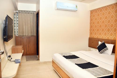 a bedroom with a bed and a television in it at Hotel Bharosa inn Naroda in Ahmedabad