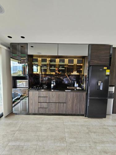 a kitchen with a black refrigerator in a room at La casa en el aire in Medellín