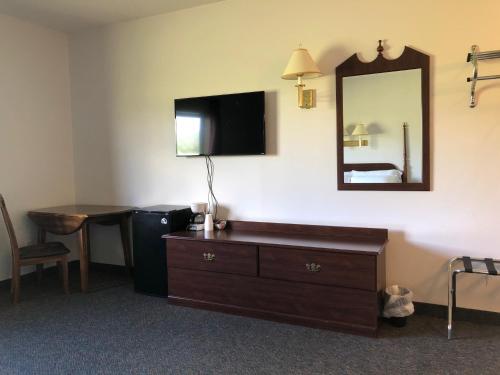 een hotelkamer met een dressoir en een spiegel bij Oakland Express Mote in Oakland