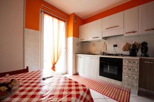 una cucina con pareti arancioni, tavolo e finestra di Casa Verena ad Aosta