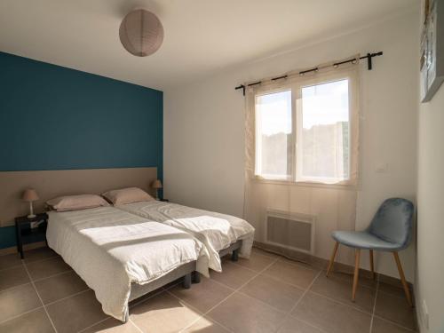Gite Les Bouches Rouges في Vesseaux: غرفة نوم بسرير وجدار ازرق