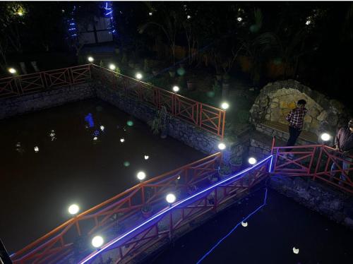 a man standing on a bridge over a river at night at Vaga Copper Castle in Vagamon