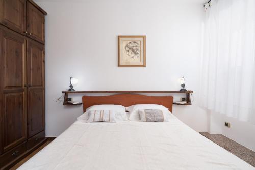 a bedroom with a white bed with two pillows at Appartamento da Manzela in Cala Gonone