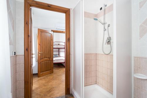 a bathroom with a shower and a glass door at Appartamento da Manzela in Cala Gonone