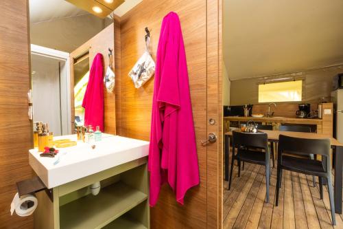 La salle de bains est pourvue d'une serviette rose accrochée au mur. dans l'établissement Camping Moulin de Paulhiac, à Daglan