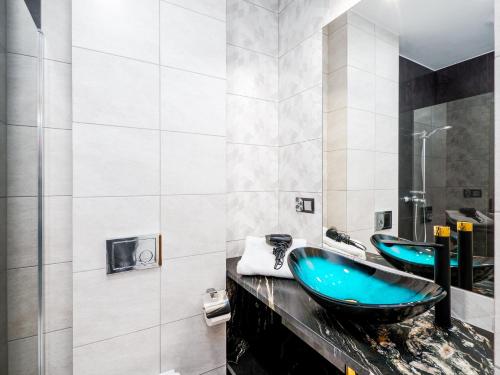 a bathroom with two blue sinks and a shower at EdelHouse in Szczawnica