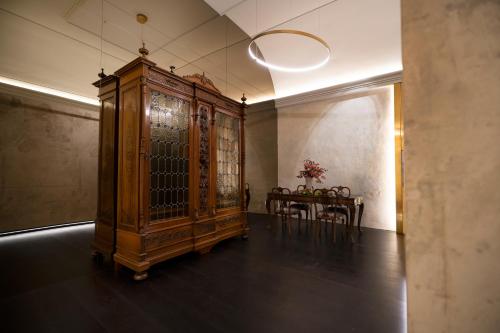 a large wooden cabinet in a room with a table at Palazzo Giusti Suites and Spa in Urbino