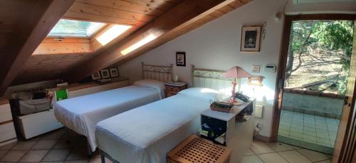 Schlafzimmer im Dachgeschoss mit 2 Betten und einem Fenster in der Unterkunft La Liguria tra gli Ulivi 2 in Varraze