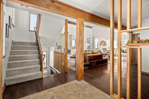 a living room with a staircase and a stair case at Tranquil Rocky MTN Retreat - Hot Tub - Evergreen in Idaho Springs