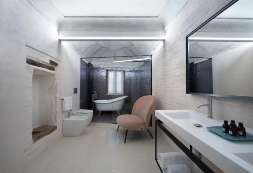 Palazzo Giusti Suites and Spa في أوربينو: حمام مع حوض ومغسلة ومرحاض
