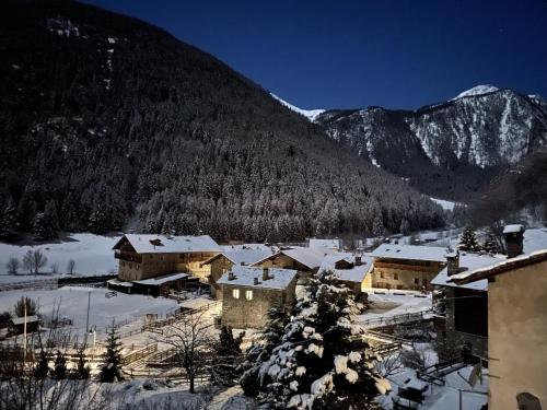 un pueblo cubierto de nieve frente a una montaña en Aux Pieds du Malatra' 2, en Saint-Rhémy-en-Bosses