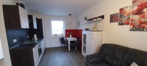 a kitchen and a living room with a couch and a table at Ferienwohnung Völkner in Hamdorf