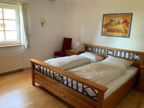1 dormitorio con cama de madera con sábanas blancas en Ferienwohnung Lindenhof en Lenzkirch