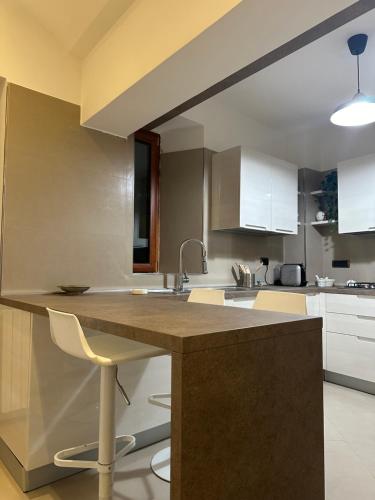 Una cocina con fregadero y una encimera con sillas. en Al Conservatorio Vecchio, en Salerno
