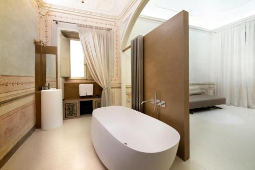 a bathroom with a large white tub in a room at Palazzo Giusti Suites and Spa in Urbino