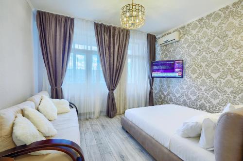 um quarto com uma cama, um sofá e uma janela em Квартири подобово біля вокзалу em Kiev