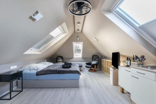 um quarto com uma cama num sótão com clarabóias em Uhse Loft em Heide