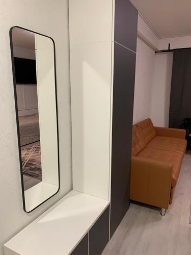 a mirror and a couch in a room at Yksiö keskustassa saunalla in Iisalmi
