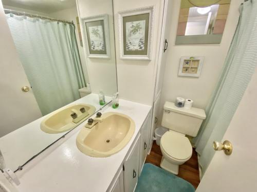 uma casa de banho branca com um lavatório e um WC em Venture Out 646 Octopus Dr Comes WITH GOLF CART em Panama City Beach