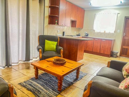 a living room with a table and a kitchen at Leribisi Lodge in Tierpoort