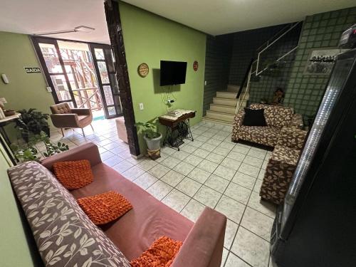 a living room with two couches and a tv at Pousada Dunas Natal in Natal