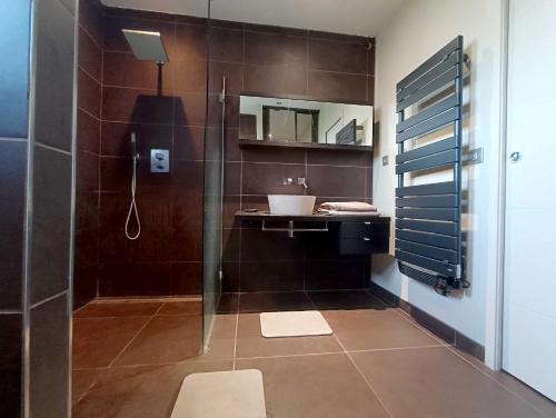 a bathroom with a glass shower and a sink at Villa Greg in Saint-Marcel-lès-Valence