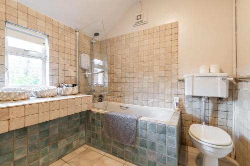 uma casa de banho com um WC, uma banheira e um lavatório. em Oakwood House em Dublin