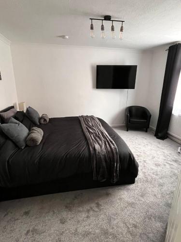 a bedroom with a bed and a flat screen tv at Eden Stays in Stivichall