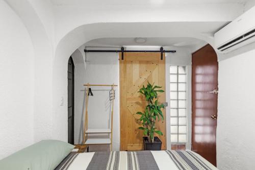 a bedroom with a bed and a wooden door at Casa Nance Alojamientos GRAN MAYA Centro Mercado 28 y ADO Doble Suite Familiar 7 Personas in Cancún