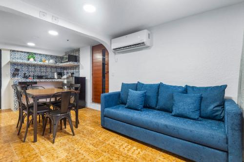 a living room with a blue couch and a table at Casa Nance Alojamientos GRAN MAYA Centro Mercado 28 y ADO Doble Suite Familiar 7 Personas in Cancún