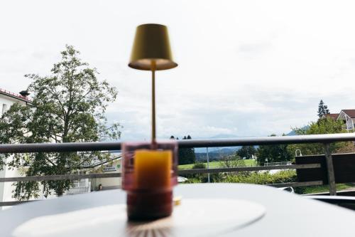 a lamp sitting on a table on a balcony at HEIMATEL - Suiten, Apartments und Studios in Scheidegg