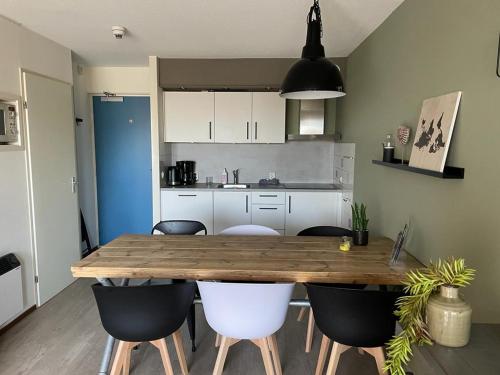 een keuken met een houten tafel en stoelen bij Appartement Senang, Resort Amelander Kaap in Hollum