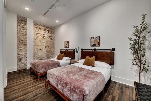 two beds in a room with white walls at Loft Style Spacious Lux Apt, Sleeps 6 in Atlanta