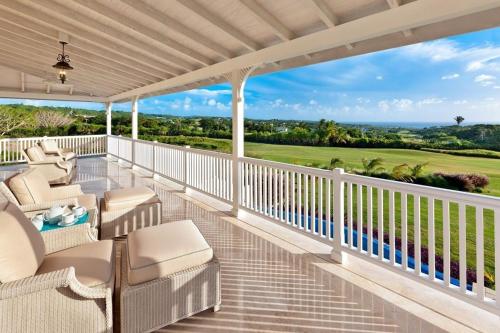 a porch with chairs and a view of the golf course at Royal Westmoreland - High Spirit by Blue Sky Luxury in Saint James